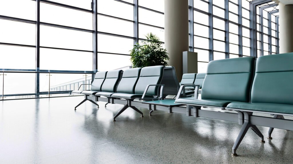 Airport departure waiting area with empty seats.